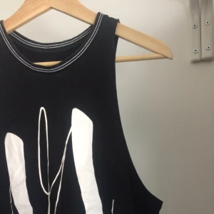  - Svart linne med urringade sidor och hög hals från rvca. Vitt tryck på framsidan samt två vita linjer i halsen.  Womens size 8 men funkar även för mindre beroende på hur man vill att den ska sitta.   Frakt ej inkluderat i priset 