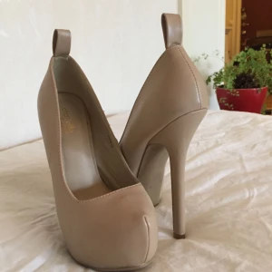  - Beiga högklackade skor köpta på Charlotte Russes. Använt 2 gånger, frakt 40kr 