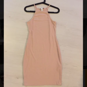  - Nude/ljusrosa tight klänning. Aldrig använd. Lappen kvar. Storlek XS från NLY Trend