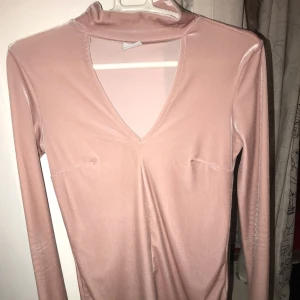  - Rosa långärmad tröja med den klassiska ”inbyggda” chokern, snäppet genomskinlig vid bysten men det löser man med en ljus bh