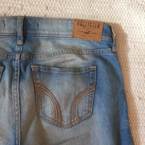  - Hollister jeans med slitningar i ljus tvätt. De är i står att de är i storlek W24, men är stora i storleken och passar mer en W26. 