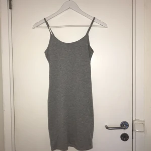  - Grå figursydd klänning med spagettiärmar.