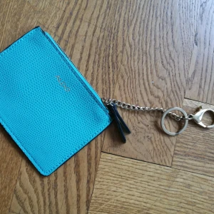  - Liten börs där kort och nyckel får plats. 