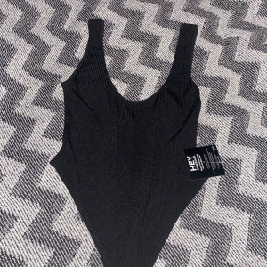 Body svart linne - Ribbad linne med djup urringning både fram och bak. Prislappen på och inte använd.                Storleken är mer som en S/M