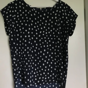 Blus - Mörkblå, prickig blus med dragkedja på baksidan. Köparen står för frakten. 