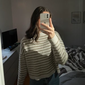 Stickad tröja  - Säljer denna vit beige randiga stickade tröjan från nakd! Den är välanvänd och har blivit lite nopprig med tvättarna men är annars i bra skick! Priset är exklusive frakt!😙