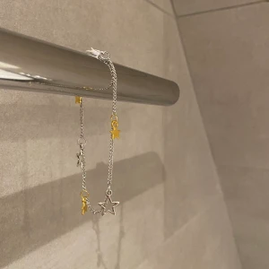 Armband, smycken - X05. Jättefint armband med stjärnor i guld och silver. Glöm inte att 10% av vinsten går oavkortat till organisationen kvinna till kvinna. 