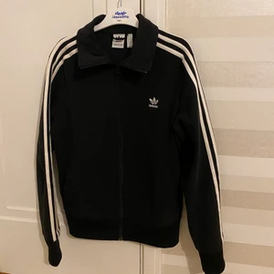 Adidas jacka/kofta  - En Adidas jacka/kofta som är i storlek 40, som en M. Den har fickor i sidan med dragkedja. Använd mycket fint skick.