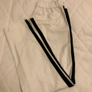 Kostymbyxor  - Vita kostymbyxor med en svart rand längs benen. Köpta på zara. Sitter snyggt och är stretchiga! Inte så långa i benen. Stl. S
