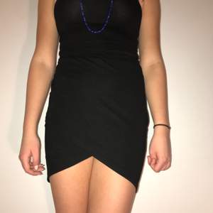 Highwaisted svart kort kjol med snygg skärning där fram. Nyskick!