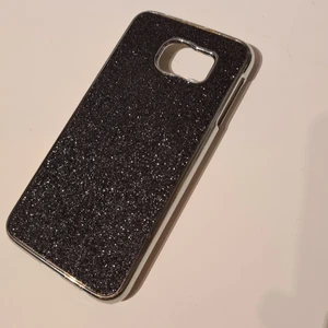 Mobilskal till Samsung galaxy S6 - Mobilskal sämjes för att jag har fått en ny mobil. Skalet är i nyskick och har knappt använts, gjort i hårdplast och med svart glittrande baksida. Pris: 30kr men kan diskuteras