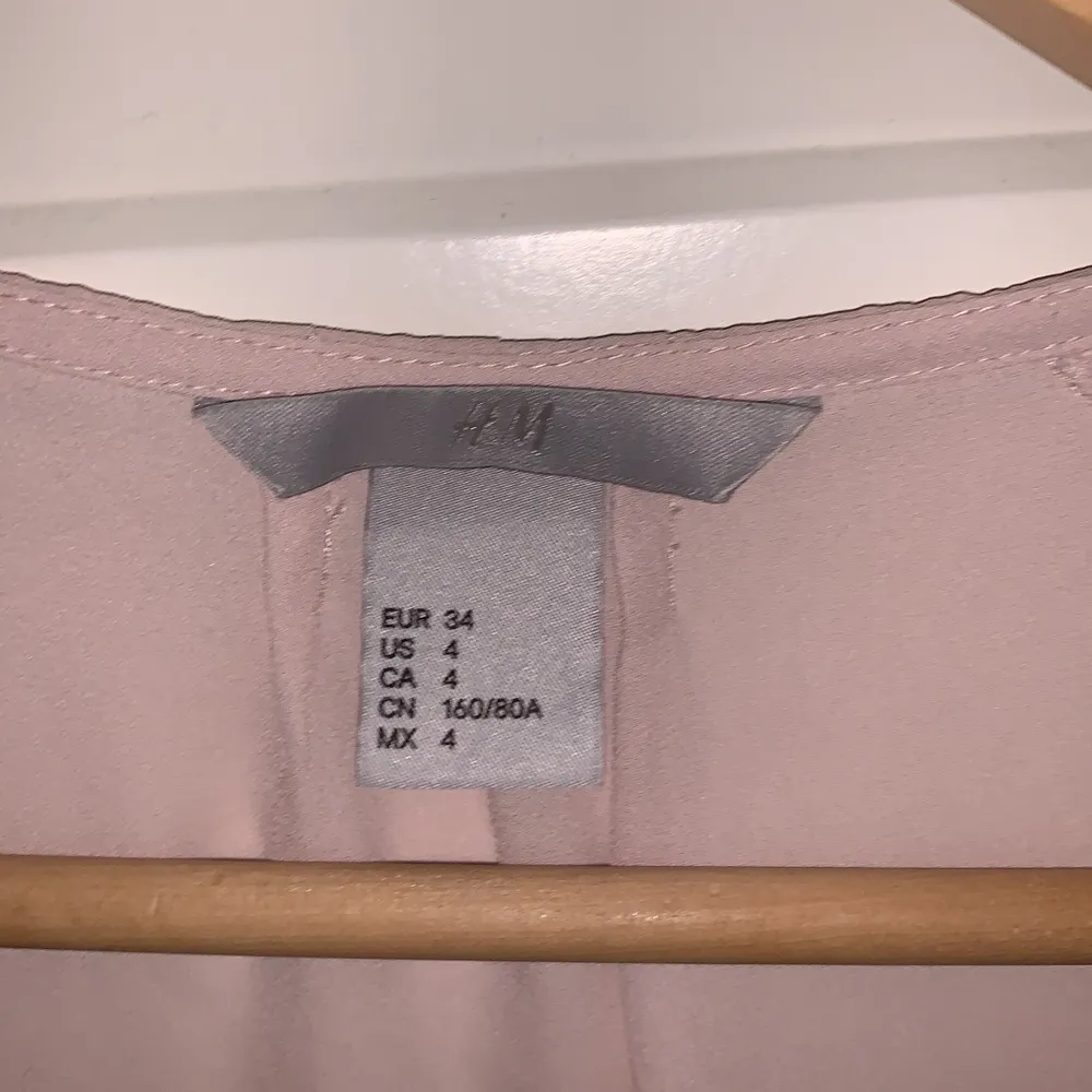 Kortärmad v-ringad blus med lite puffiga armar från H&M i en rosa/beige färg.  Använd bara ett fåtal gånger, den har supersnyggt fall. I storlek 34, säljer för 60kr. . Blusar.