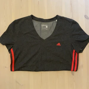 Adidas T-shirt  - Mörkgrå Adidas T-shirt med rosa detaljer i storlek M