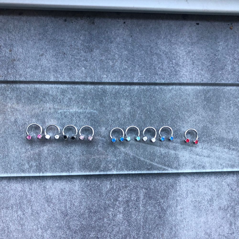 Olika piercing smycken från laboro lagret. Stavar, bananabell, ringar med kula, segmenteringar, hästskor med kula samt koner (andra tillbehör finns), labretter, navelpiecing smycken, örhängen, armband, halsband, berlocker, ringar och mycket mer. Finns i äkta silver, titan och kirurgiskt stål😊 hör av er vid köp o frågor. Smycken på bilden från 29kr. 99kr för septum med Sten.. Accessoarer.