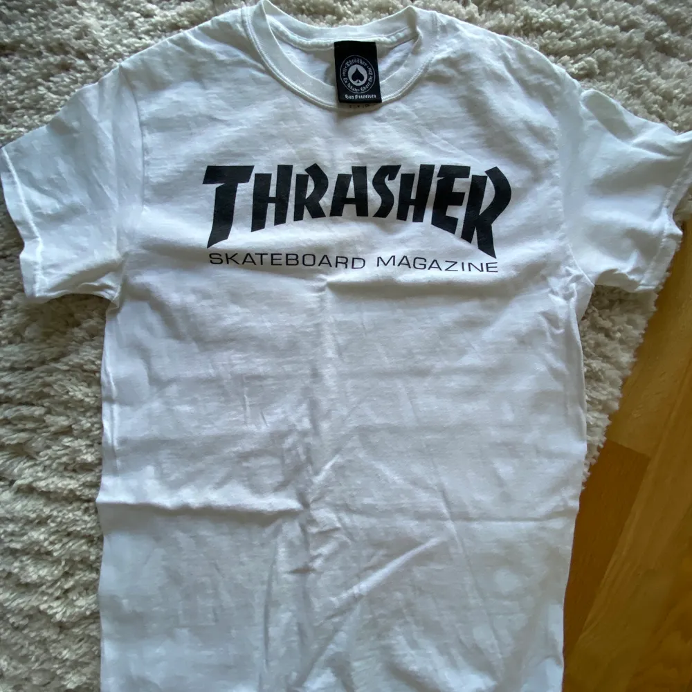 Vit supersnygg THRASHER T-shirt i storlek S men är en aning stor så funkar som M likaså. Använd Max fem ggr och legat i garderob oanvänd i något år så superfint skick! . T-shirts.