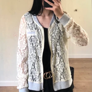 Kofta i spets strl S - Kofta i spets med gråa ärmar, grå nedtill samt grå krage. Lapparna är bortklippta, därav vet jag ej märket. Liten fläck på ena ärmen. Gott skick. 50 kr frakt.