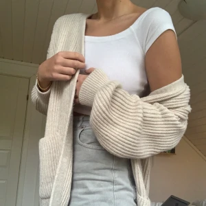 Stickad kofta  - Super mjuk och stretchig kofta/cardigan från NAKD, jättefin men har så många liknande så måste sälja. Inköpt för ca 1 månad sedan, bara använd hemma några gånger så superbra skick! Har en liten tråd som gått upp, se bil. Nypris 349. Frakt 63kr