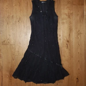 Klänning till barn - Festlig klänning i storlek 152 (barnstorlek). Rosetten är sliten och två stenar i urringningen har trillat av men är i övrigt en väldigt fin och festlig klänning. Kanske till halloween? Frakt inkluderat. 