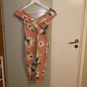 Blommig klänning - Säljer min sköna blommiga klänning. Vid axlarna finns det ett slags klisterband som får den att ej åka ner. Använd under ett tillfälle endast.