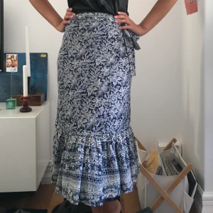 Mönstrad omlottkjol - Fint mönstad omlottkjol i midi-längd. Knappt använd så i gott skick! Köparen står för frakten (ca 50kr) eller möts upp i Stockholmsområdet❤️