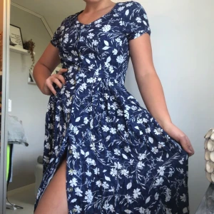 Sommarklänning strl S - Sval och skön sommarklänning i blått med blommigt mönster. Lika snygg knäppt knäppt som uppknäppt och i fint skick.