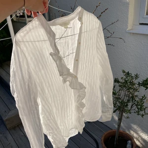 Blus från H&M - Söt randig blus från H&M med volanger vid knäppningen! Fint skick, nästan aldrig använd. För liten för mig som normalt är en S, därför skulle jag säga att den är mer som en XS elr XXS 🌸