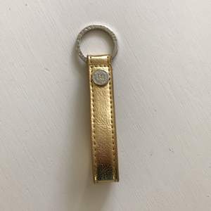 Guld nyckelring från märket don donna med silver detalj. Helt ny. 30kr ink frakt. 