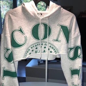 Cropped hoodie från H&M devided!  - Detta är en jättefin ljusgrå cropped hoodie med grön text. Använd ett fåtal gånger och är i bra skick, utan märken osv.🦋 Startpris: 190kr exklusive frakt💕 Hör av dig vid frågor/intresse!
