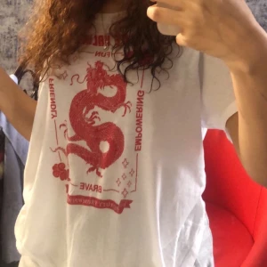 T-shirt - Vit tröja med röd dragon på. Storlek M