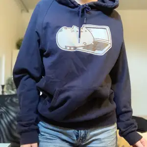 En mörkblå hoodie med Pusheen som tryck! 