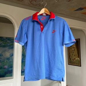 Nike Piké - Riktigt snygg Nike Piké med coola detaljer på ärm, axel och på undersidan av kragen. Sitter snyggt på mig som passar i S. Köparen står för frakt!
