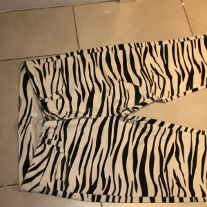 Zebra-mönstrade jeans - Jeans med zebra-mönster. Använda en gång för ett foto. Storlek S, ungefär 1 m långa och 33 cm breda