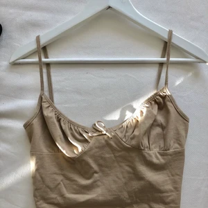 Gullig topp - Säljer en beige, jättegullig topp med en rosett i fram pga av den va för liten för mig. Endast använd en gång så den är som sprillans ny!😊 säljer för 79kr! Köparen står för frakten💜