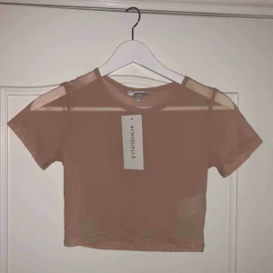  - Helt oanvänd mesh-topp i beiget. 