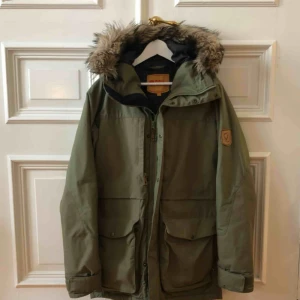  - Fjällräven Barents parka, herrmodell, i fint skick. Nypris: 4999 ”Rejäl, vattentät parkas med syntetfoder för växlande vinterväder. Ombonad huva med avtagbar bräm i syntetpäls.”