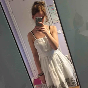  - Vit söt klänning med blom detaljer. Använd en gång. Har en pytteliten fläck på kjol, syns knappt. Köpare står för frakt :)