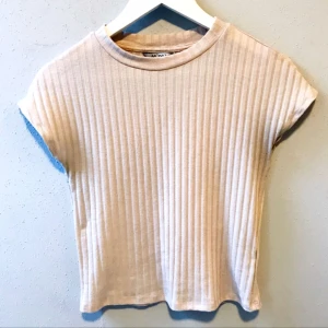  - Ljusrosa T-shirt i kortare modell i storlek XS från Monki säljes för 20kr, frakt tillkommer. Betalning sker via swish.