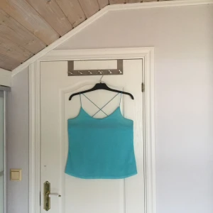  - Turkost linne i skönt svalt material. Tunn axelband som korsas i ryggen. Fint skick och väldigt snyggt. 