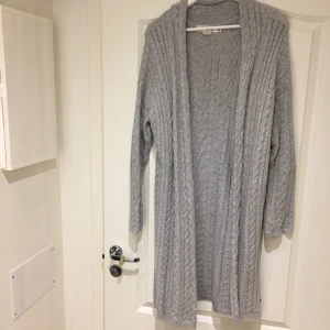  - Lång, stickad kofta från H&M i storlek M. Skön och fin på. Köparen står för frakten.