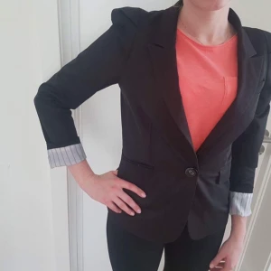  - En svart kavaj i ett bra skick.