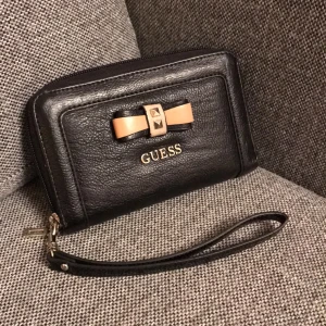  - Guess plånbok, får plats med en iPhone 5 i. Använd 1 sommar men i bra skick 