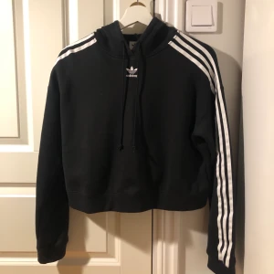 Croppad hoodie från Adidas - Fin croppd hoodie från adidas. Använd några fåtal gånger, säljer pga att jag har växt ifrån stilen.