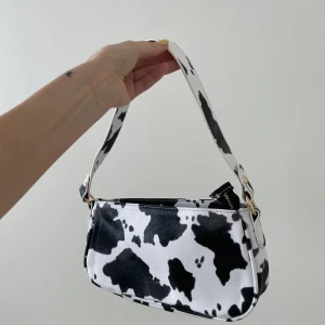 Väska med komönster - Supersöt väska som tyvärr inte kommer till användning. Garderobsrensning så kolla gärna in mina andra annonser🐻🤎☁️⚡️