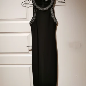 Klänning med paljetter - Svart kroppsnära klänning med pärlor/paljetter. Använd enbart 1 gång. 