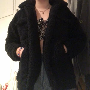 Svart teddy jacka - En svart tjockare teddy jacka från Monki. Köpt för ca 2 år sedan men inte använd sen dess. Mer äv en vinterjacka men funkar nu under tidig vår också. Kan mötas i Malmö/Lund annars står köpare för frakten (69kr)!