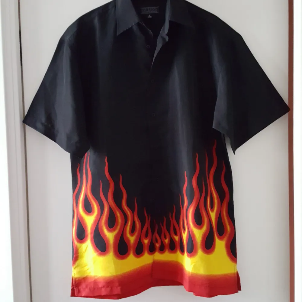 Vintage svart skjorta med eldflammor på. Storlek S men är stor i storleken och mer som ca en storlek L. Kan skickas om köparen står för frakten som blir 36kr.. Övrigt.