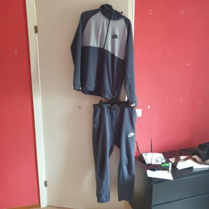  - Nike tracksuit i storlek large Toppen har 2st fickor med dragkedja byxorna har 3st fickor 2st på sidorna med dragkedja och 1 bak 