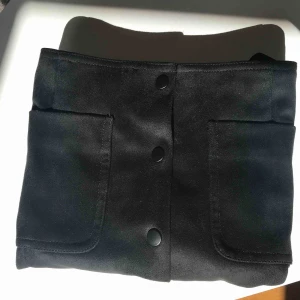  - Mocka kjol i svart. A-formad kjol som sitter tajt i midjan. I fint skicka och knappt använd. Knapparna sitter ordentligt och går inte bara upp om man rör sig. 