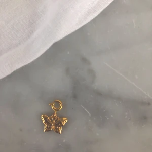 Fjärilsberlock - Guldig fjärilsberlock från j.selma.p! Helt oanvänd! Funkar på både halsband och armband!