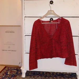 Mönstrad röd blus från H&M - Mönstrad, croppad, röd blus från H&M med knäppning framtill. V-ringad. Köparen står för frakt 🧡